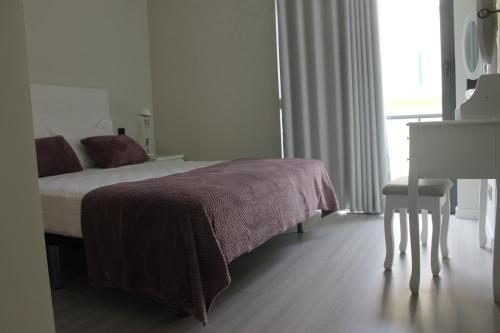 a bedroom with a bed and a table and a desk at Duque de Loulé - Apartments - Apartamento G in São Martinho do Porto