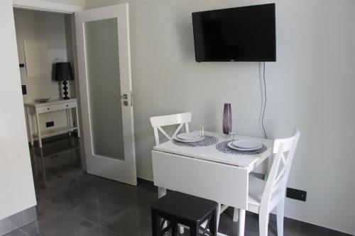 a white table with two chairs and a tv on a wall at Duque de Loulé - Apartments - Apartamento G in São Martinho do Porto