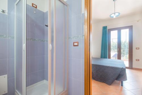 a bathroom with a shower and a bed in a room at Holiday home in Cala Gonone 34367 in Cala Gonone
