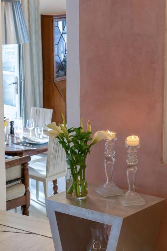 a table with a vase of flowers and candles on it at Semeli Hotel Mykonos in Mýkonos City