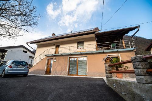 a house with a car parked in front of it at Apartments Ole in Tolmin
