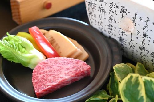 a plate of food with meat and vegetables on a table at 原鶴の舞 in Asakura