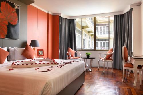 um quarto com uma cama grande e paredes cor-de-laranja em Memoire Siem Reap Hotel em Siem Reap