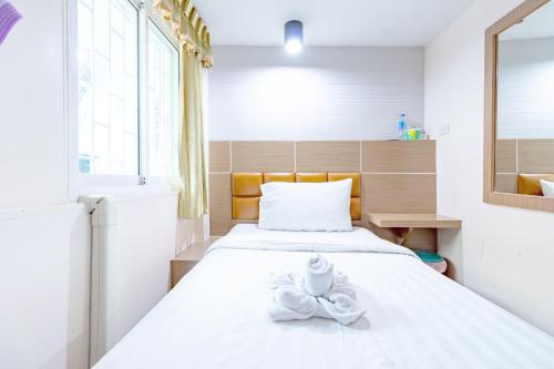 a bedroom with a bed with a towel on it at Oun Residence in Hat Yai