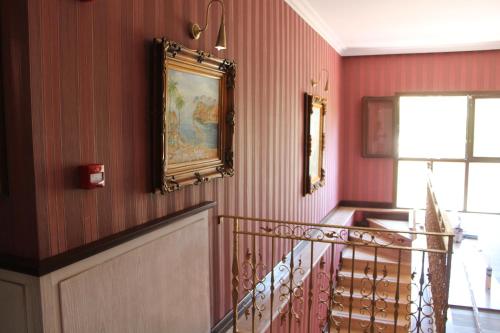 a hallway with a staircase with a painting on the wall at Bella View Art Boutique Hotel in Kérynia