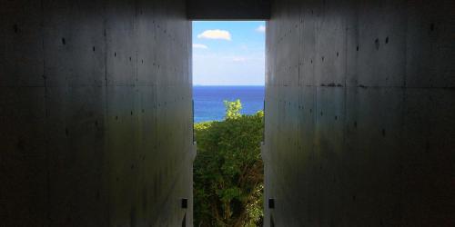 a view of the ocean from inside a building at SOU東恩納 in Uruma