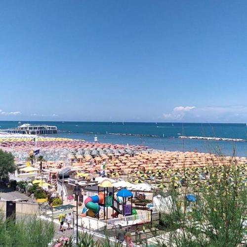 a beach filled with lots of people and umbrellas at Residence Margherita in Cattolica
