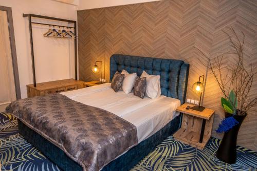 a bedroom with a large bed with a blue headboard at ART Hotel in Sibiu