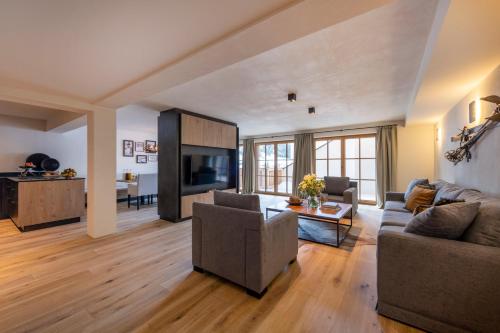 a living room with a couch and a tv at Brunnenhof Luxury Apartments in Lech am Arlberg
