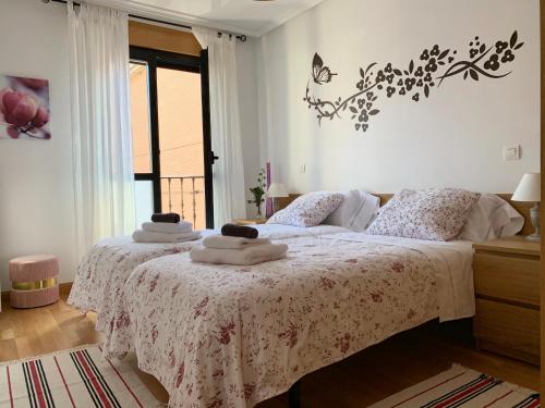 una camera da letto con un letto e asciugamani di La Vie en Rose Piso en el centro a Briviesca