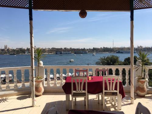 a table and chairs on a balcony with a view of the water at El Mesala Hotel in Luxor