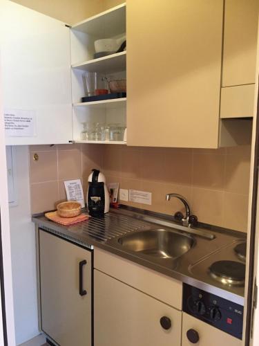 a kitchen with a sink and a counter top at Hotel Garni Villa del Sole in Ponte Tresa