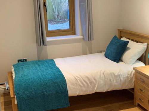 Un dormitorio pequeño con una cama con ventana. en Chestnut-Lodge is rural, secluded, private with Hot Tub, en Maidstone