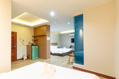 a hotel room with a bed and a bathroom at Oun Residence in Hat Yai