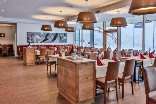 a dining room with tables and chairs and windows at Lizum 1600 | Kompetenzzentrum Snowsport Tirol in Axamer Lizum
