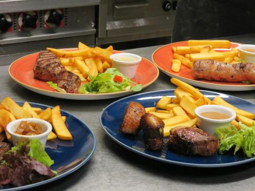 three plates of food with meat and french fries at Hotel le Faisan in Saint-Avertin