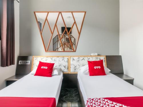 2 camas en una habitación con almohadas rojas en OYO Hotel Park Leste, São Paulo, en São Paulo