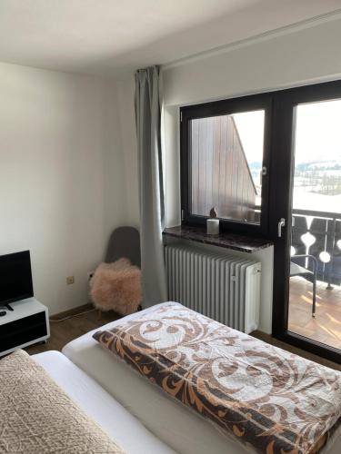 a bedroom with a bed and a window with a balcony at Mondstein in Hauzenberg