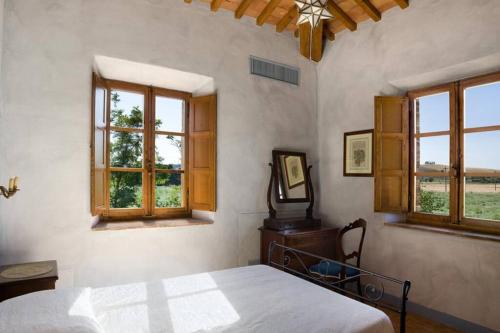 a bedroom with a bed and two windows at Villa Ponte in Ponte dʼArbia