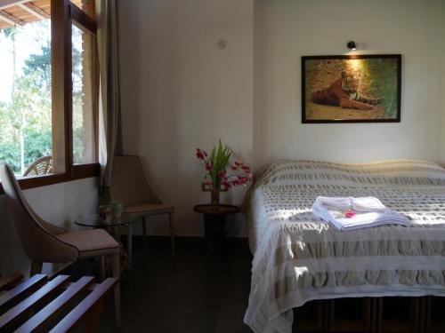 a bedroom with a bed and a picture on the wall at Estate Stay - Riverside Coffee in Siddapur