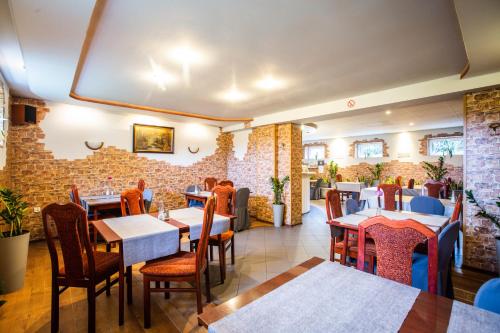 a restaurant with tables and chairs and a brick wall at Hotel Margo in Cedynia