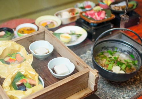 a table topped with a tray of food with bowls of food at Okuhida Garden Hotel Yakedake in Takayama