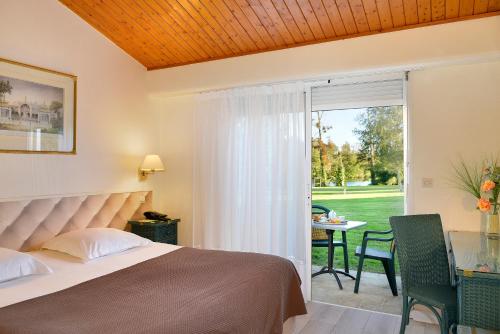 Una cama o camas en una habitación de Logis Hôtel Val de Vienne