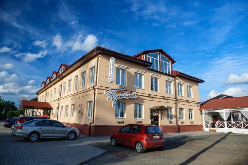 un edificio con dos coches estacionados frente a él en Hotel Pushkin, en Pskov