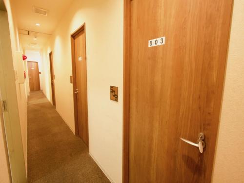 a hallway with a door leading to a room with a door leading to a at Osaka Guesthouse Nest in Osaka