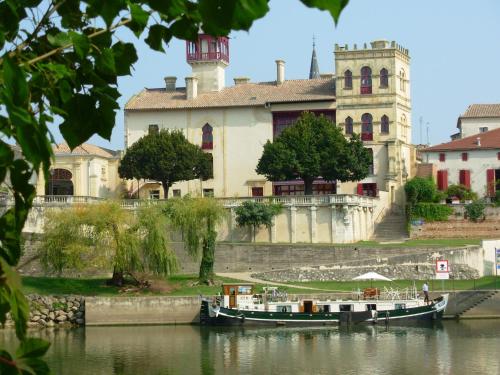 two boats in the water in front of a building at Lagrange Grand Bleu Vacances – Résidence Port Lalande in Castelmoron-sur-Lot