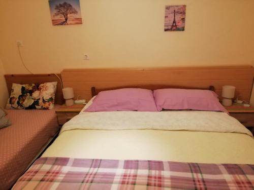 uma cama num quarto com duas almofadas em Apartman Lara em Brodarica