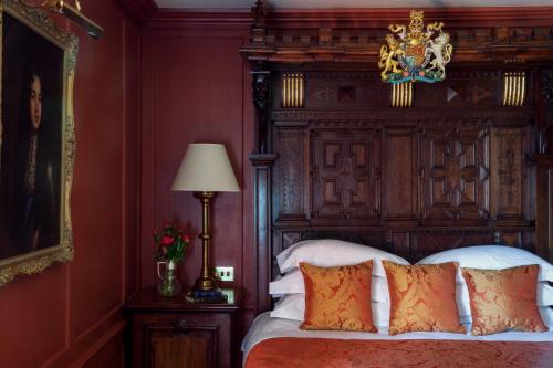 a bedroom with a large bed with a wooden headboard at Hazlitt's in London