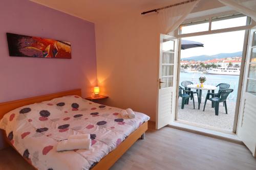 a bedroom with a bed and a table with chairs at Seaside Apartment Franica in Vela Luka