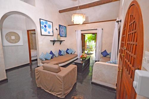 a living room with a bed and a couch and a chair at Villas Sur Mer in Negril