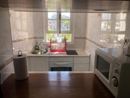 a kitchen with a sink and a microwave at Parque Santiago II Tenerife in Arona