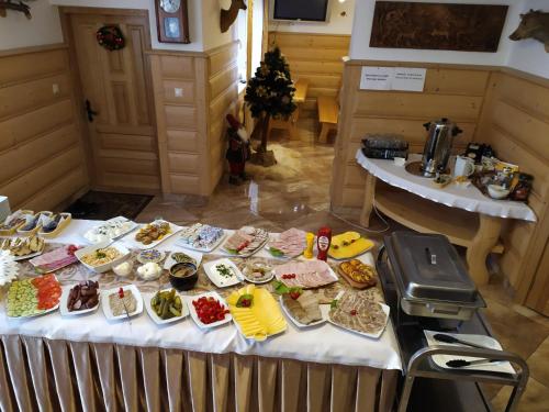 een tafel met veel verschillende soorten voedsel erop bij Podhalanski Dworek z Jacuzzi in Białka Tatrzanska