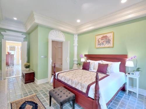 a bedroom with a large bed and green walls at MonPanaNont Wellness Resort & Spa in Mae Taeng