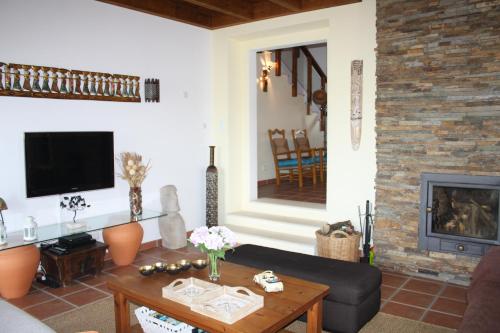 a living room with a couch and a fireplace at Monte da Sapaleira in Aljezur