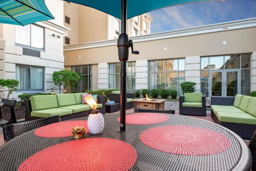 a patio with two tables and an umbrella at Holiday Inn Indianapolis North-Carmel by IHG in Carmel