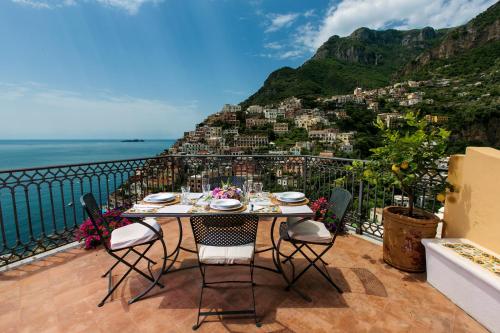 uma mesa numa varanda com vista para a montanha em Palazzo Margherita em Positano