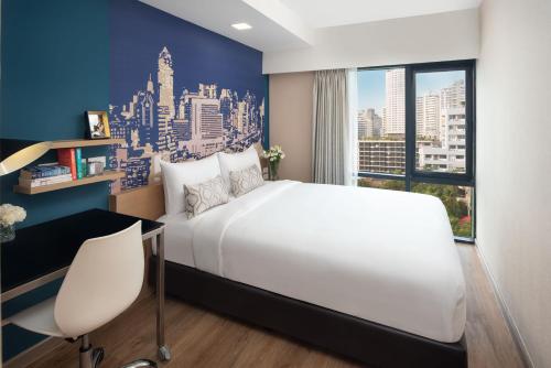 a bedroom with a large white bed and a window at Citadines Sukhumvit 8 Bangkok in Bangkok