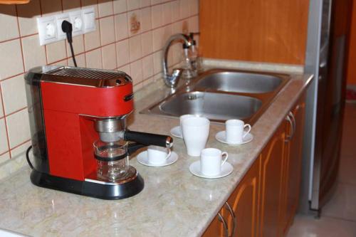 a red coffee maker on a counter next to a sink at Entire Home in Budapest