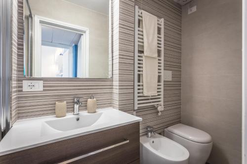 a bathroom with a sink and a toilet and a mirror at Scricciolo in Viareggio