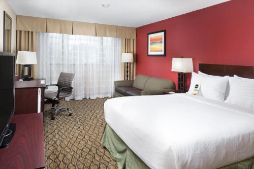 a hotel room with a large bed and a desk and chair at Holiday Inn Johnson City by IHG in Johnson City