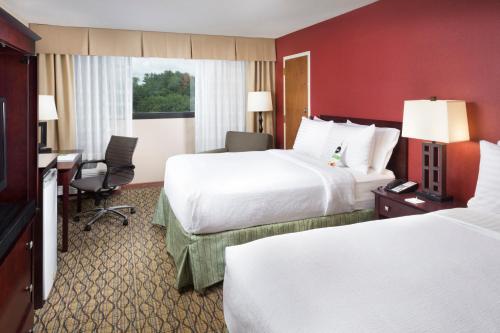 a hotel room with two beds and a desk at Holiday Inn Johnson City by IHG in Johnson City