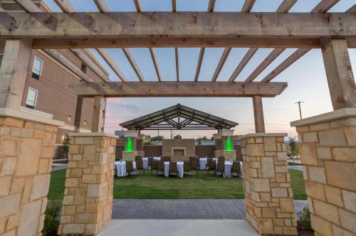 an outdoor pavilion with white tables and chairs at Holiday Inn San Marcos Convention Center by IHG in San Marcos