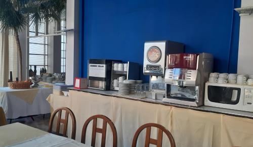 a counter in a restaurant with a microwave and appliances at Hotel Colibrì in Finale Ligure