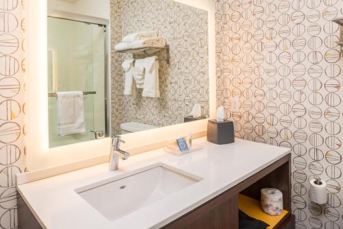 uma casa de banho com um lavatório branco e um espelho. em Holiday Inn Joplin, an IHG Hotel em Joplin