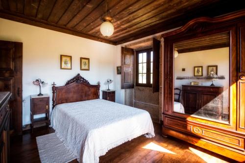 um quarto com uma grande cama de madeira num quarto em Casa Da Quinta Do Rei em Ponte de Lima