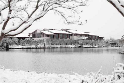a house by a lake in the snow at Holiday Inn Kunshan Huaqiao by IHG in Kunshan